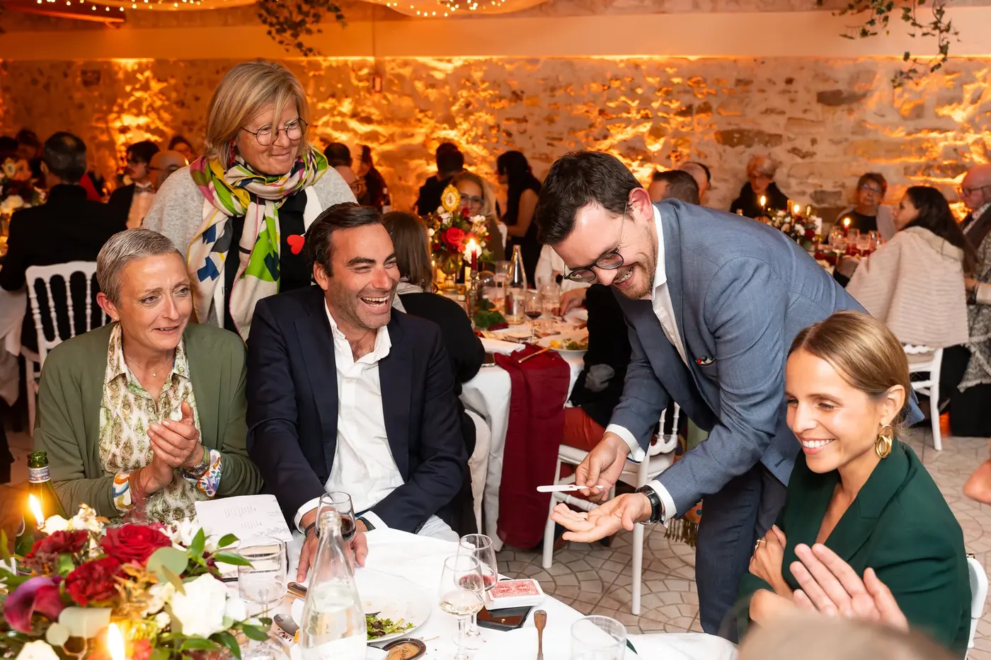 Des invités rient à une table pendant un mariage